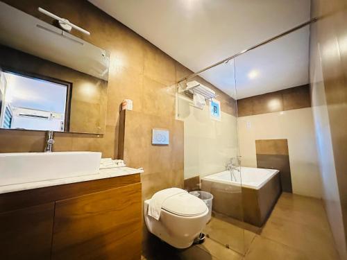 a bathroom with a toilet and a sink and a tub at City Palace Residency Nilambur in Wandūr