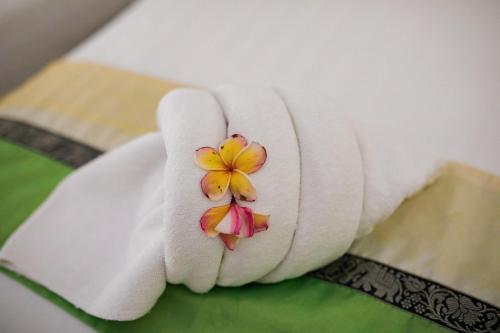 a hand with a towel with a flower on it at Chareena Beachside in Ko Lipe