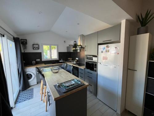 une cuisine avec un réfrigérateur blanc et un comptoir dans l'établissement Belle maison à Barbâtre, 800m plage, pour 7 personnes avec jardin clos, terrasse et WiFi gratuit - FR-1-823-69, à Barbâtre