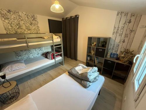 une chambre avec deux lits superposés et une table dans l'établissement Belle maison à Barbâtre, 800m plage, pour 7 personnes avec jardin clos, terrasse et WiFi gratuit - FR-1-823-69, à Barbâtre