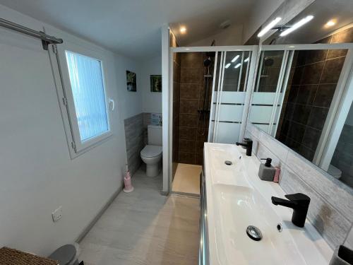 une salle de bain avec un lavabo, des toilettes et un miroir dans l'établissement Belle maison à Barbâtre, 800m plage, pour 7 personnes avec jardin clos, terrasse et WiFi gratuit - FR-1-823-69, à Barbâtre