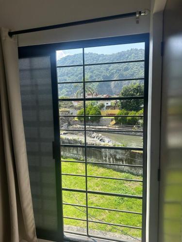 a window with a view of a green field at The best view of the river apartments garden in Orizaba