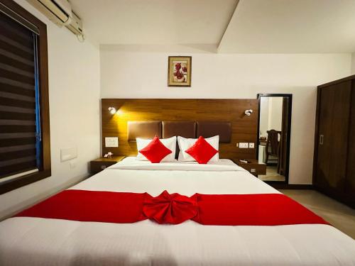 a bedroom with a bed with a red bow tie on it at City Palace Residency Nilambur in Wandūr