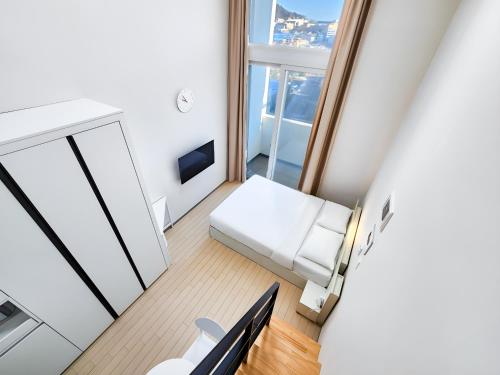 a small living room with a white couch and a window at 벨라 레지던스 in Chuncheon