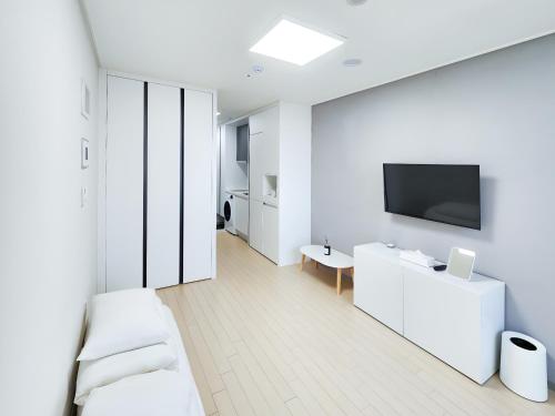 a white room with a tv on a wall at 벨라 레지던스 in Chuncheon
