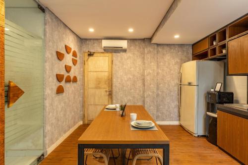 a kitchen with a wooden table and a refrigerator at Cove Renata in Seminyak