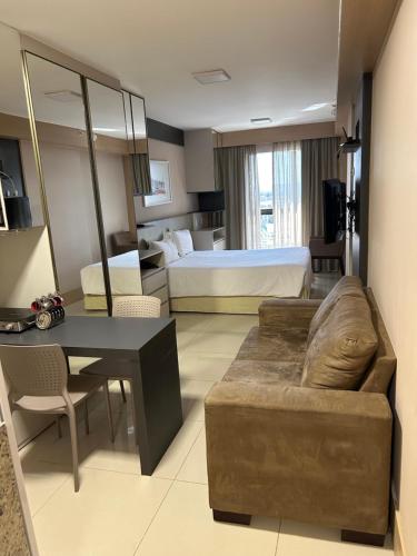a living room with a couch and a bed at Flat em Cullinan, 5 estrelas com vista incrível e incrível área de lazer com piscinas, brinquedoteca, academia, no coração de Brasília in Brasilia