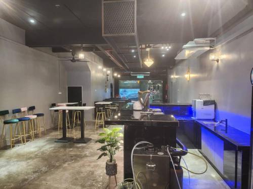 a room with a bar with stools and a table at Captain Hotel Cafe & Bistro in Sitiawan