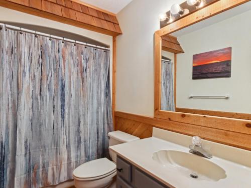 a bathroom with a sink and a toilet and a mirror at 2030 - Horizon`s Summit in Duck