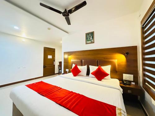 a bedroom with a large bed with red pillows at City Palace Residency Nilambur in Wandūr
