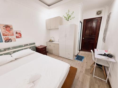 a white bedroom with a white bed and a desk at 202 부이비엔 도보 10분 , 아늑한 주택 in Ho Chi Minh City