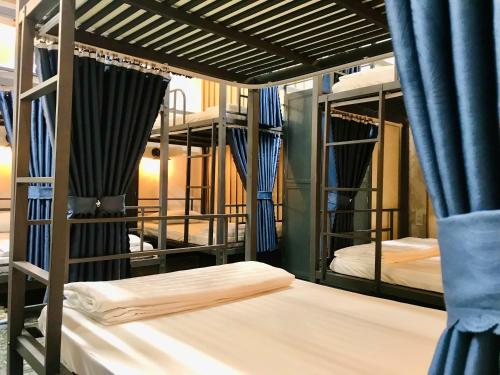 a room with three bunk beds with blue curtains at Cozy 86 Homestay in Can Tho