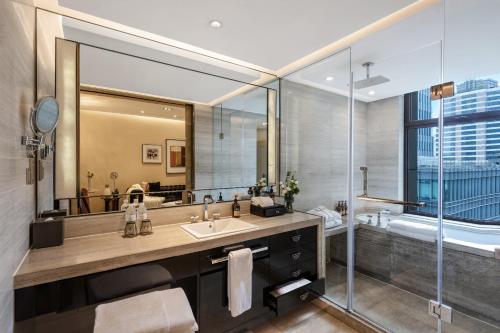 a bathroom with a sink and a large mirror at Kempinski The One Suites Hotel Shanghai Downtown in Shanghai