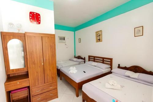 a bedroom with two beds and a mirror at Palm Grove Saud Holiday Complex Hotel in Laoag