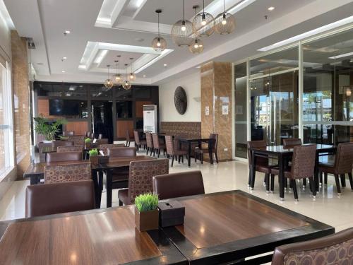 a restaurant with wooden tables and chairs and a dining room at DIVERSION 21 HOTEL in Iloilo City