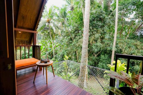 a room with a balcony with a view of the forest at Ubud Jungle Stay by WAHM Hotel Management in Ubud