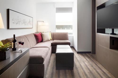 a living room with a couch and a tv at Hyatt House Dallas / Frisco in Frisco