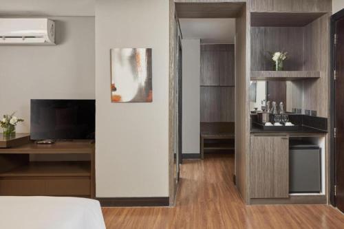 a hotel room with a bed and a television and a room at F1 Hotel Manila in Manila
