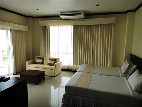 a hotel room with a bed and a couch at Kasem Garden Hotel Surin in Surin