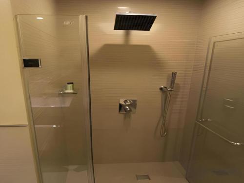 a shower with a glass door in a bathroom at F1 Hotel Manila in Manila