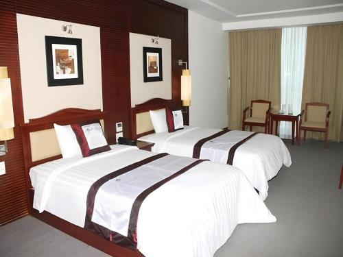 a hotel room with two beds in a room at BMC Ha Tinh hotel in Ha Tinh