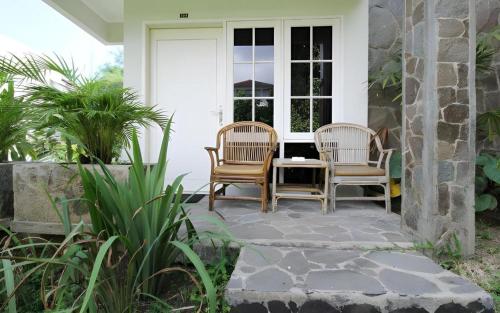 two chairs and a table on a porch at Hotel Minahasa in Manado