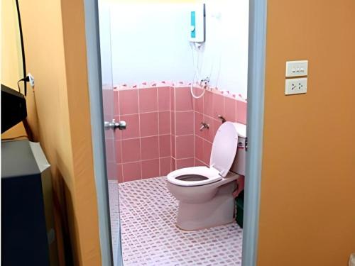 a bathroom with a toilet in a pink bathroom at Phoem Phoon 2 Hotel in Nan