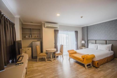 a hotel room with a bed and a television at Romance Hotel Srinakarin in Bangkok