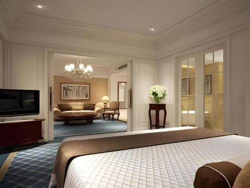 a bedroom with a bed and a living room at Zhengzhou Yiquan International Hotel in Zhengzhou