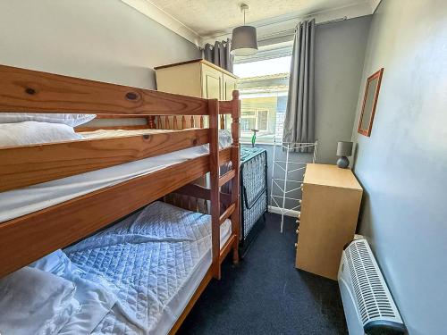 two bunk beds in a room with a window at Homely Chalet On A Brilliant Holiday Park In Lowestoft Ref 12004B in Lowestoft