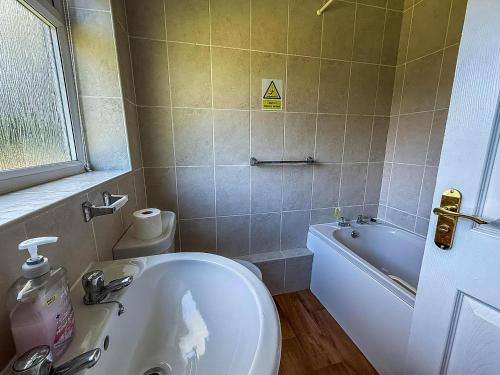 a bathroom with a toilet and a bath tub at Homely Chalet On A Brilliant Holiday Park In Lowestoft Ref 12004B in Lowestoft