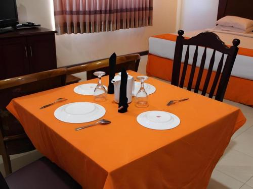 a table with plates and utensils on top of it at Hotel Dynasty in Tarakan