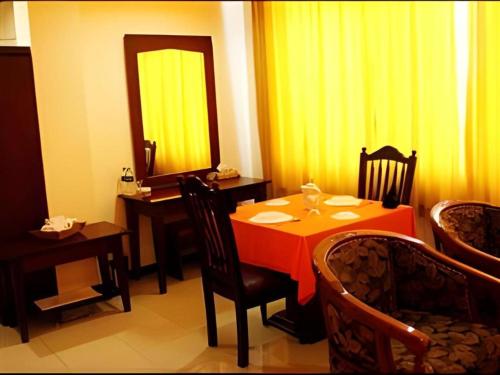 a dining room with a table and a mirror at Hotel Dynasty in Tarakan