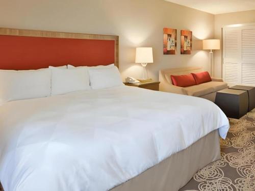 a bedroom with a large white bed and a couch at Hotel San Diego-Rancho Bernardo in San Diego