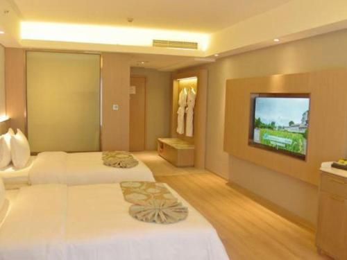 a hotel room with two beds and a flat screen tv at Chengdu Antai Century Hotel in Chengdu