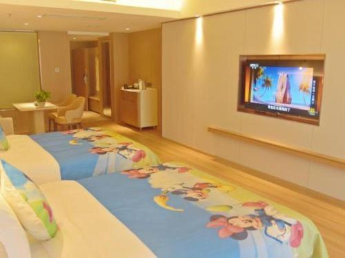 a hotel room with two beds and a flat screen tv at Chengdu Antai Century Hotel in Chengdu