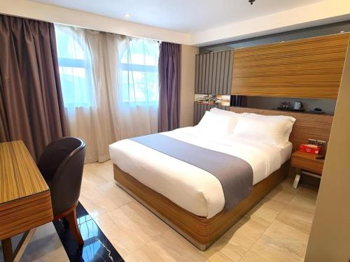 a hotel room with a bed and a desk at Hong Thai Hotel in Macau