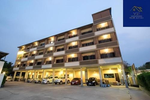 a large building with cars parked in a parking lot at V51 Hotel in Nakhon Ratchasima