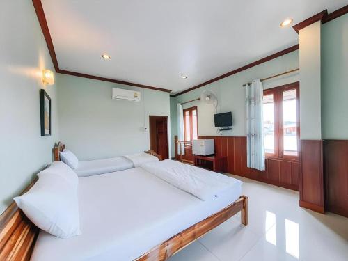 a large bedroom with a large white bed in it at Ban Glai Kong in Chiang Khan