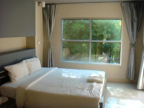 a bedroom with a large bed and a window at A+ Hotel in Ubon Ratchathani