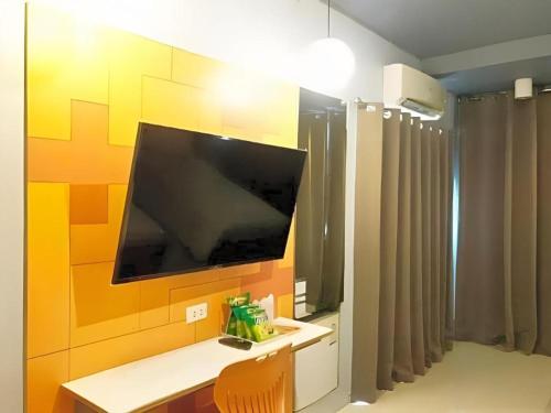 a room with a television on a wall at A+ Hotel in Ubon Ratchathani