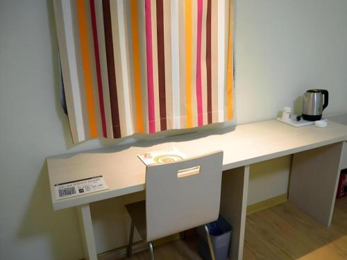 a desk in a room with a colorful curtain at 7 Days Inn Jinan Changqing Jingshi West Road Center in Jinan