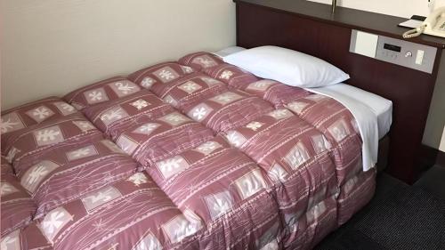 a large bed in a hotel room at Hotel Town Nishikigawa in Kochi