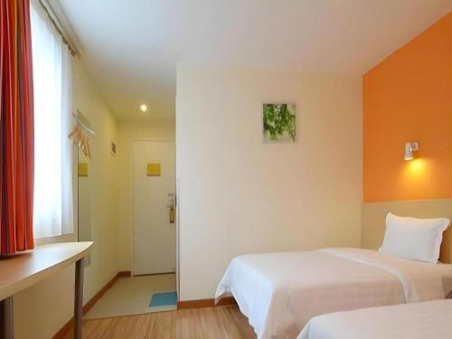 a hotel room with two beds and a window at 7 Days Inn Luoyang Wangcheng Park Metro Station in Luoyang
