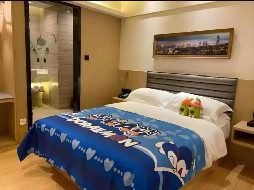 a bedroom with a large bed with a blue blanket at Metropolo Hotel Qingdao Wusi Square Xiaomaidao in Qingdao