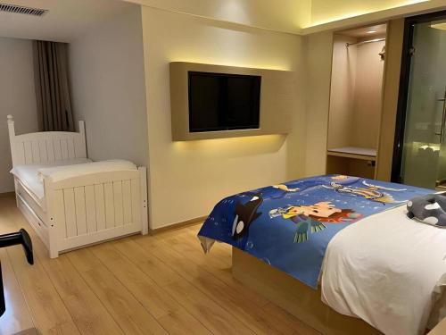 a bedroom with a bed and a flat screen tv at Metropolo Hotel Qingdao Wusi Square Xiaomaidao in Qingdao