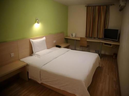 a bedroom with a white bed and a television at 7 Days Inn Nanjing Gaochun Metro Station in Gaochun