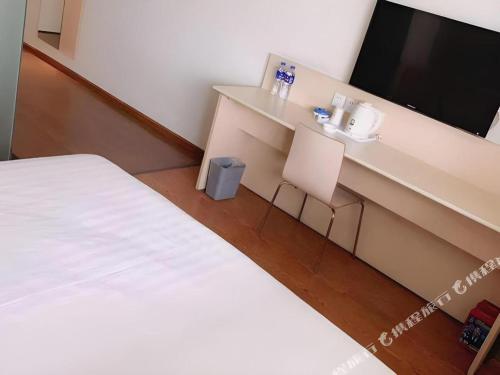 a hotel room with a bed and a flat screen tv at 7 Days Inn Chengdu North Railway Metro Station in Chengdu