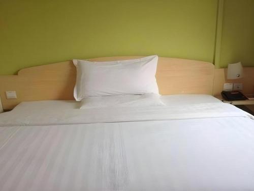 a large white bed with two pillows on it at 7 Days Inn Nanjing Gaochun Metro Station in Gaochun