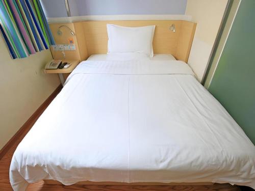 a large white bed in a small room at 7 Days Inn Chengdu North Railway Metro Station in Chengdu
